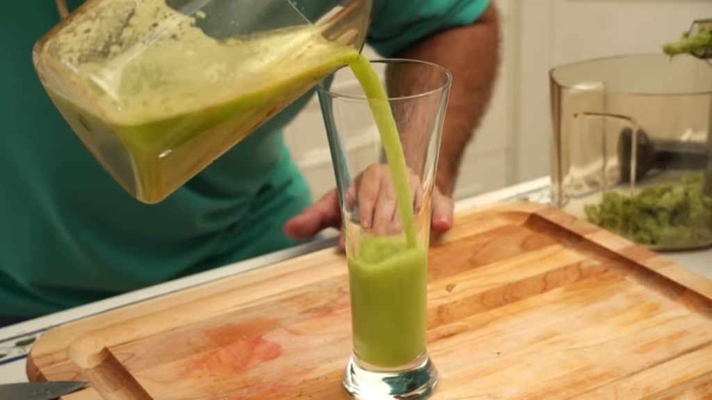 Pouring broccoli juice in glass.