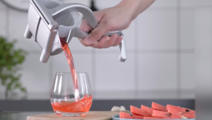 pouring juice from hand juicer