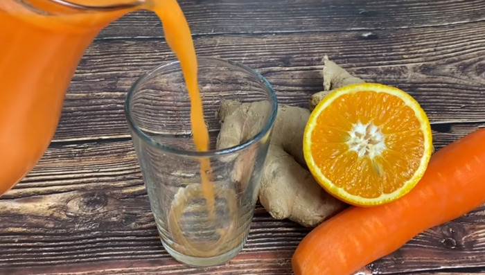 pouring carrot juice in glass