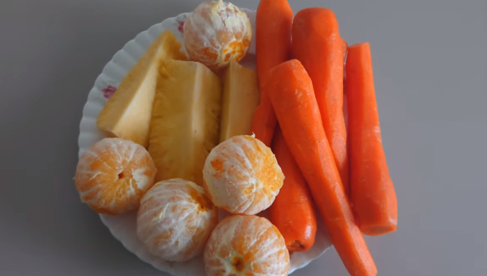 carrots, pineapple and orange in plate