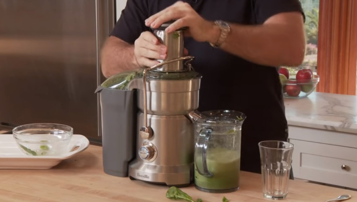 making mean green juice in juicer