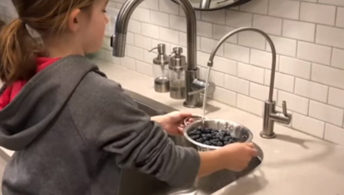girl is washing blueberries