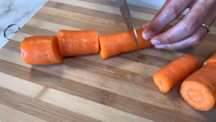 cutting carrot on cutting board with knife